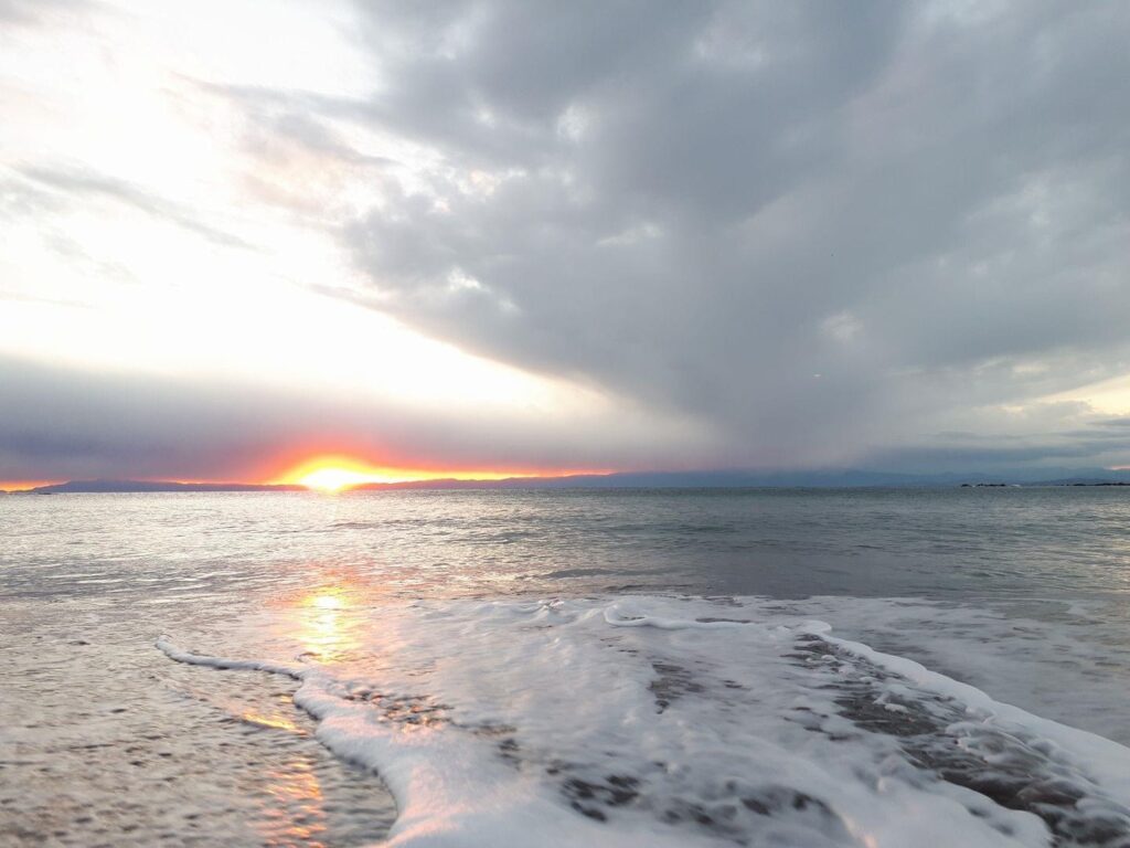 日の出の時、白い波が立つ葉山の海