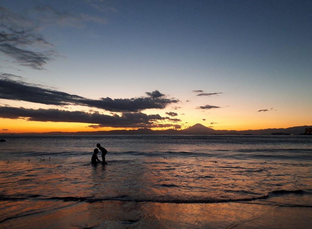 夕暮れ時に葉山の海で遊ぶ子供達