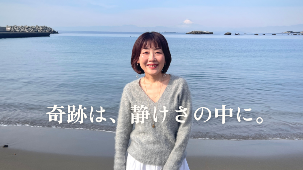 海で微笑む友里「奇跡は、静けさの中に。」のメッセージ